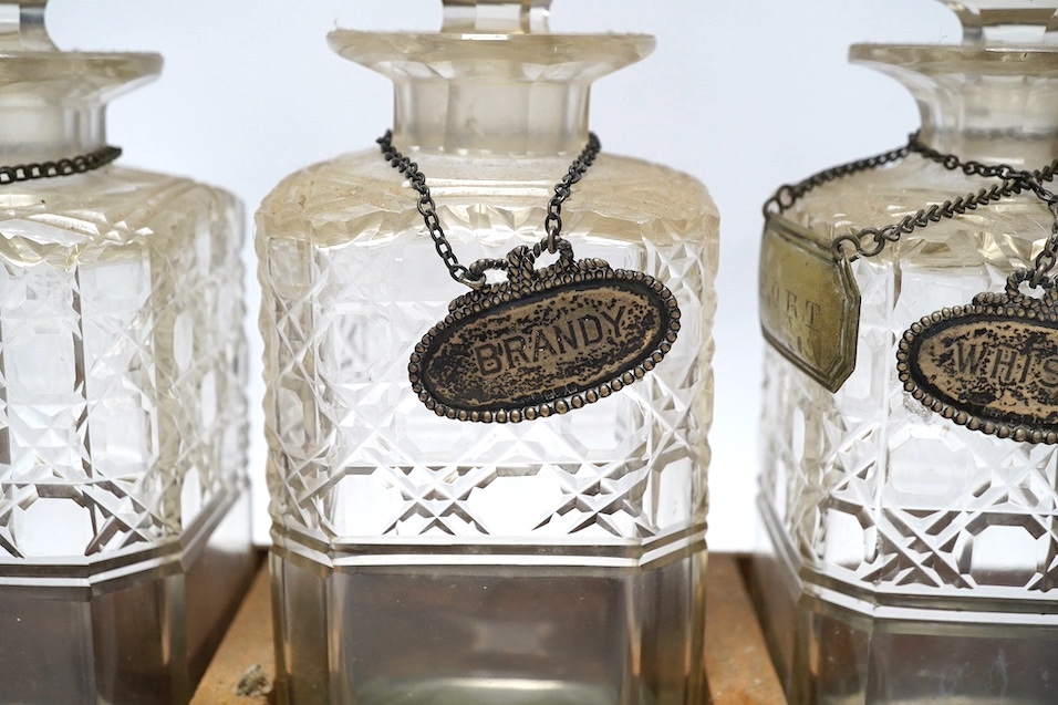 A Victorian oak three decanter tantalus with four spirit labels, and key, 37cm wide. Condition -fair